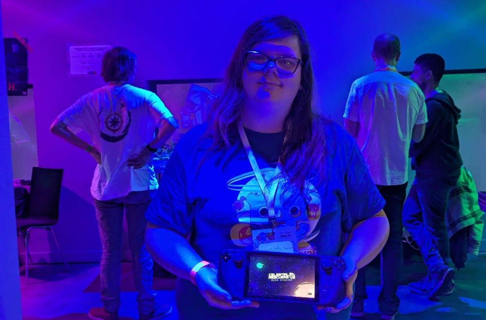 A woman holding a Steamdeck with the game Celestial Rescuers 2 at GodotCon